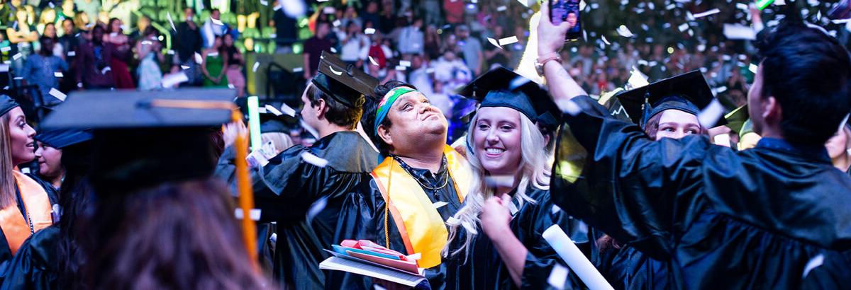 两名皮马大学毕业生在五彩纸屑飘落的同时庆祝毕业